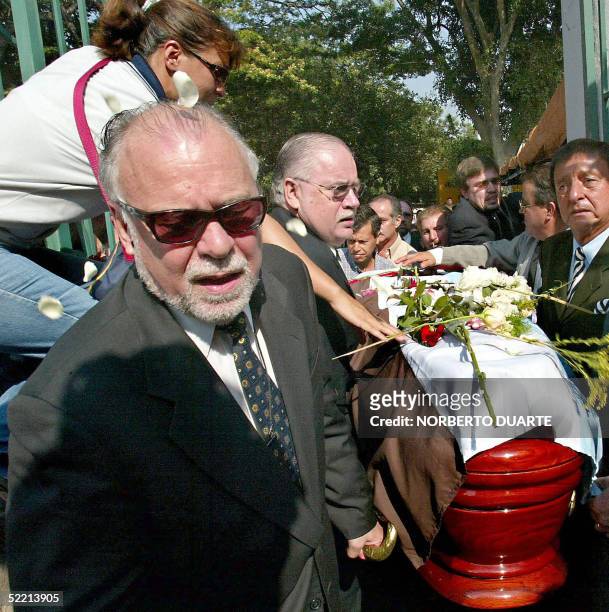 Former Paraguayan President Raul Cubas arrives at the cemetery carrying the coffin of his daughter Cecilia Cubas, in Asuncion, 18 February 2005. Five...