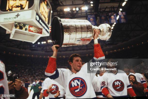 Brent Sutter of the New York Islanders hoists the Stanley Cup over his head after the Islanders defeated the Edmonton Oilers for the NHL championship...