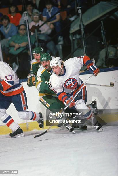 Canadian pro hockey player Brent Sutter, forward for the New York Islanders, skates away from Minnesota North Stars forward Dennis Maruk during a...