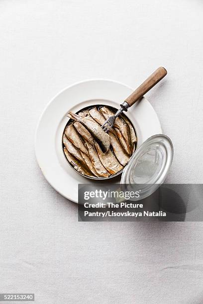 sprats in can and fork on white background - sprat fish stock pictures, royalty-free photos & images