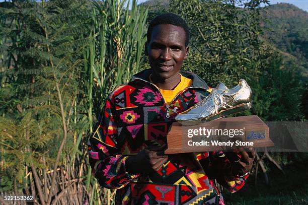 runner paul tergat holding trophy - achievement logo stock pictures, royalty-free photos & images