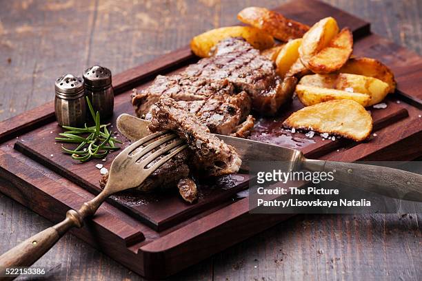 sliced well done grilled new york steak with roasted potato wedg - lob wedge stock-fotos und bilder