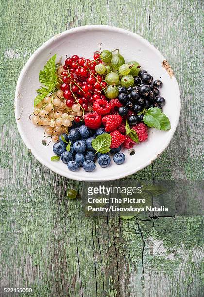 mix of fresh berries with leaves in vintage ceramic colander on - currant fruit stock pictures, royalty-free photos & images