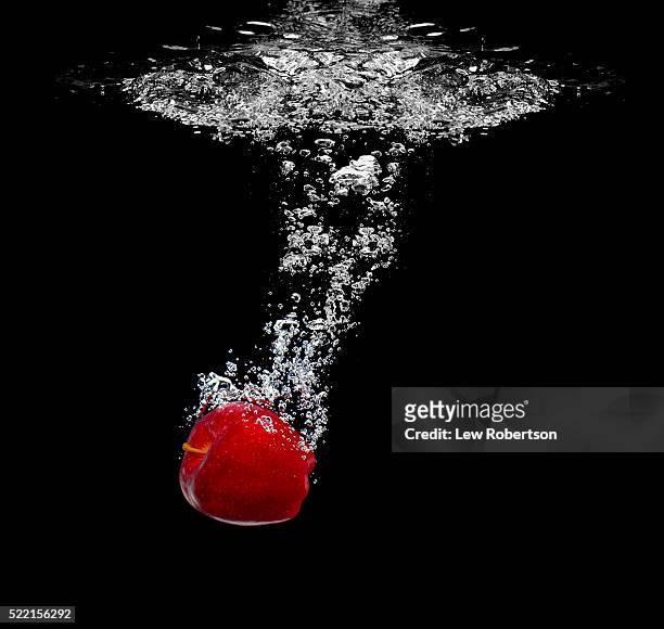 apple sinking in water - sinking stock pictures, royalty-free photos & images