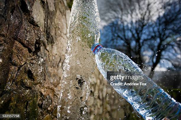 water bottle being filled with mineral water - destilliertes wasser stock-fotos und bilder