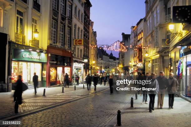 people strolling past storefronts - kleinhandel stockfoto's en -beelden
