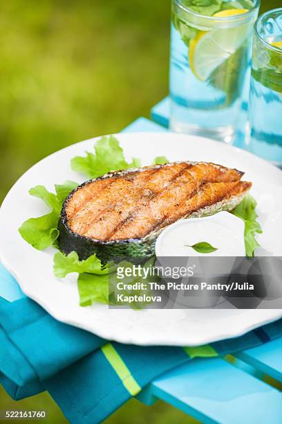 grilled salmon steak on a fresh green salad with garlic sauce - redfish stockfoto's en -beelden