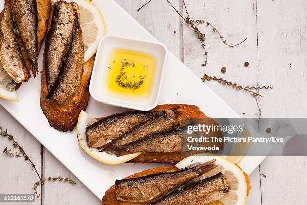fish, spanish tapas - sprat with lemon on baked bread - sprat fish stock pictures, royalty-free photos & images
