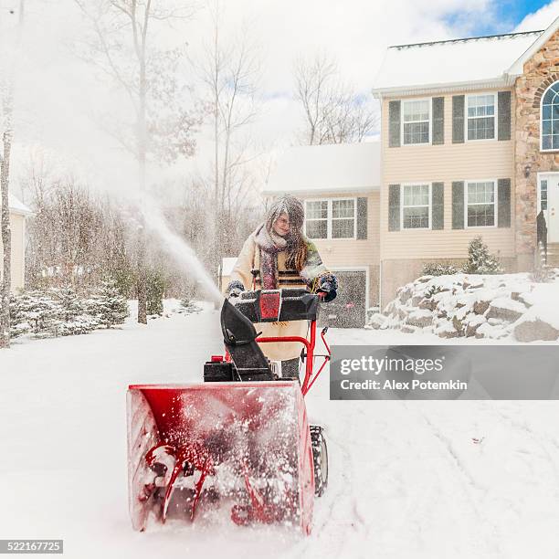 teenager girl remove the snow with snowplow - strooigoed stockfoto's en -beelden