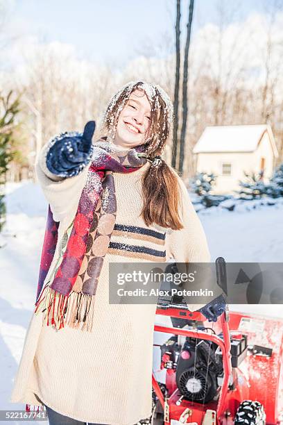 teenager girl remove the snow with snowmashine - strooigoed stockfoto's en -beelden