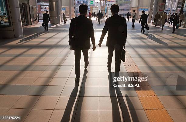 early morning business commuters at shinagawa station in tokyo, japan - image stock pictures, royalty-free photos & images