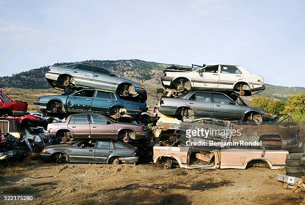 stacked cars in junkyard - autoschrottplatz stock-fotos und bilder