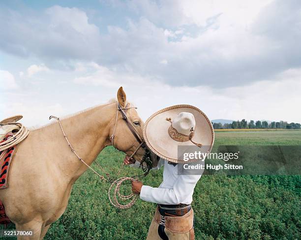 cowboy talking to his palomino horse - chapeau mexicain photos et images de collection