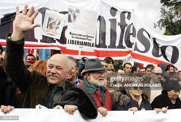 Kidnapped Italian journalist Giuliana Sgrena's companion Pier Scolari waves flanked by her father Franco Sgrena and mother Antonietta as they march...