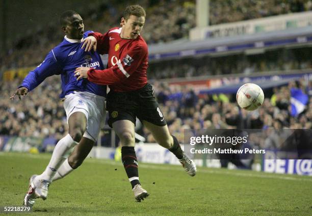 Wayne Rooney of Manchester United clashes with Joseph Yobo of Everton during the FA Cup Fifth Round match between Everton and Manchester United at...