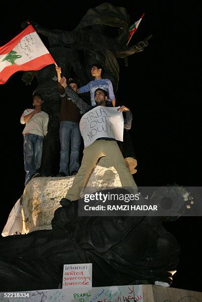 Demonstrators, holding national flags and anti-Syrian banners, stand on Beirut's landmark Martyrs Statue during a protest 19 February 2005, against...