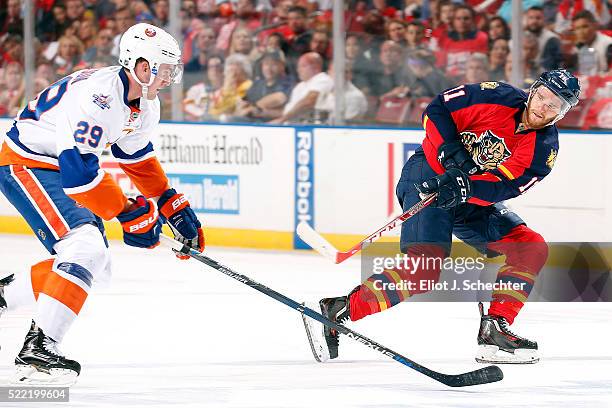 Jonathan Huberdeau of the Florida Panthers passes the puck against Brock Nelson of the New York Islanders in Game One of the Eastern Conference...