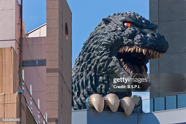 giant godzilla statue atop toho cinema in the shinjuku kabukicho district of tokyo, japan - godzilla stockfoto's en -beelden