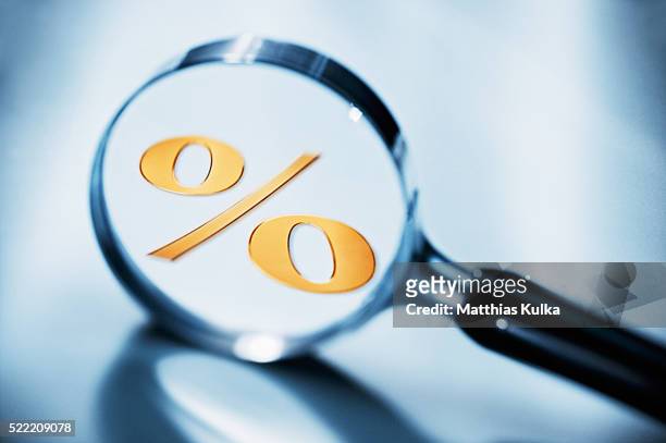 percent sign in magnifying glass - interest stockfoto's en -beelden