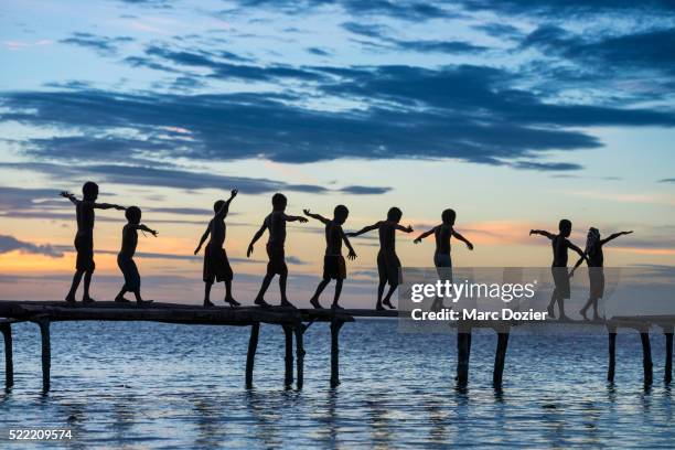 papuan children in sunset - papuma beach stock pictures, royalty-free photos & images