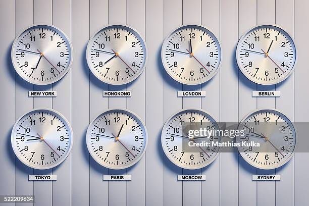 clocks showing time differences - zona horaria fotografías e imágenes de stock