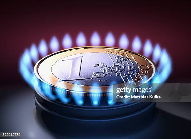 euro coin on natural gas stove burner - aardgas stockfoto's en -beelden
