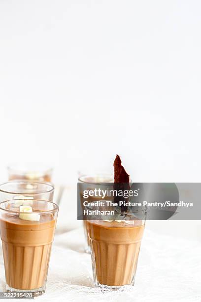chocolate panna cotta garnished with white chocolate curls served in glasses - panna cotta photos et images de collection