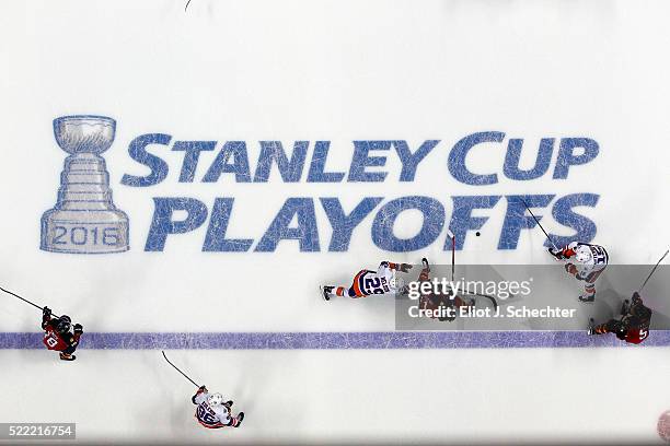 Jonathan Huberdeau of the Florida Panthers skates with the puck against Cal Clutterbuck and teammate Brock Nelson of the New York Islanders in Game...