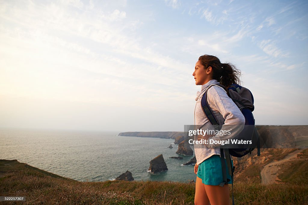 Profile of female hiker on Atlantic coastline.
