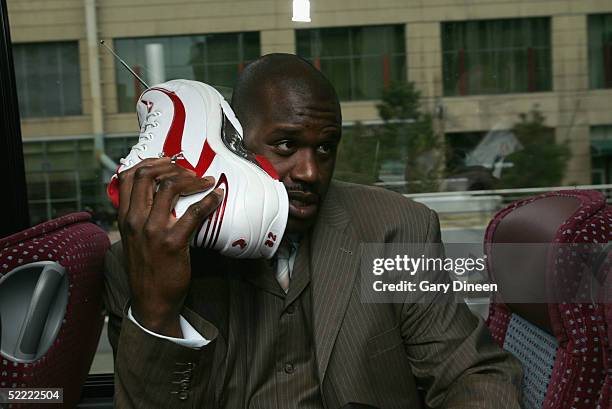 Shaquille O'Neal of the Eastern Conference All-Stars talks on his sneaker phone as he rides the bus to the Arena for the 54th All-Star Game, part of...