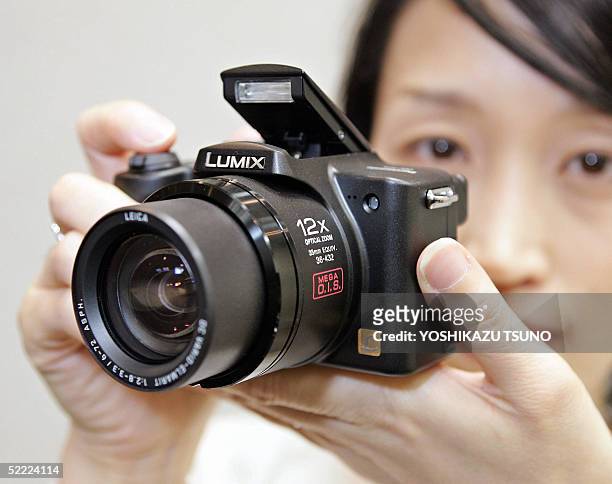 Employee for Japanese electronics giant Matsushita Electric Industrial, Shiho Yoshida, displays the new digital camera "Lumix DMC-FZ5", equipped with...