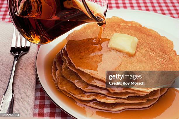 pouring maple syrup on plate of pancakes - pancake stock-fotos und bilder