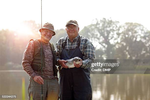 senior fishermen with rod and fresh catch - man catching stock pictures, royalty-free photos & images