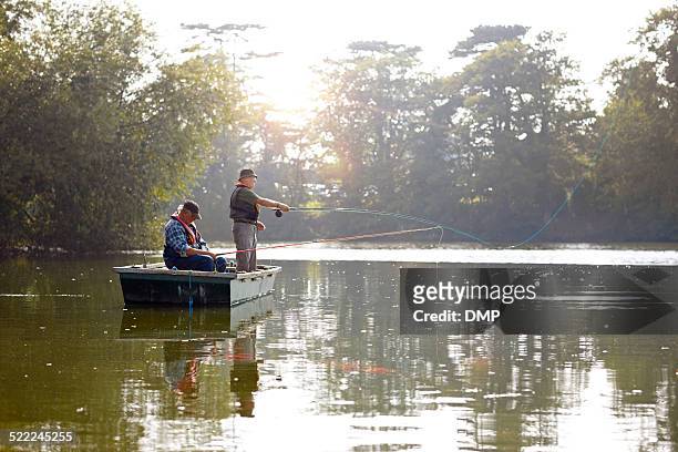 two senior men in a boat fishing - small boat stock pictures, royalty-free photos & images