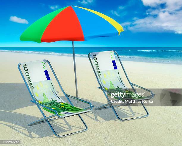 two deckchairs and a sunshade at beach - vakantiegeld stockfoto's en -beelden