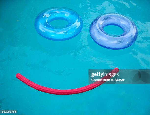swimming pool floats forming smiley face - swimming float stock pictures, royalty-free photos & images