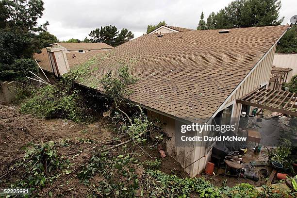 Wall on a condominium is seen broken open after a 10-foot wall of mud smashed through it, filling the home to the ceiling and trapping three women...