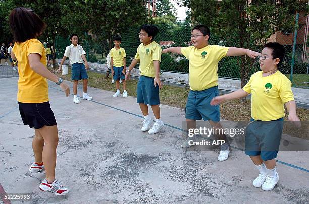 Overweight students guided by their fitness teacher during a physical exercise lesson at their school in Singapore ,15 February 2005. AFP PHOTO/Debby...