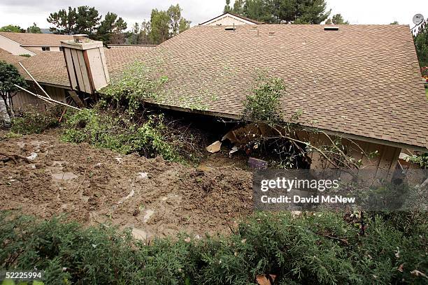 Wall on a condominium is left broken open after a 10-foot wall of mud smashed through it, filling the home to the ceiling and trapping three women...