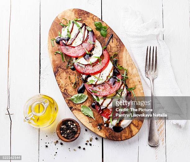 caprese salad tomato and mozzarella slices with basil leaves on - caprese stock-fotos und bilder