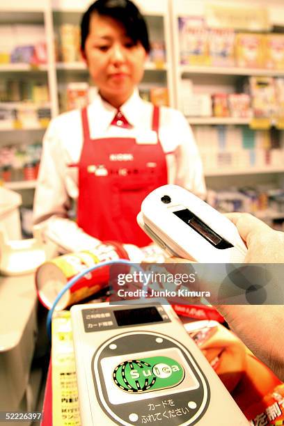 DoCoMo's mobile phone is placed on a reader to pay at a kiosk during a press conference on February 22, 2005 in Tokyo, Japan. East Japan Railway, NTT...