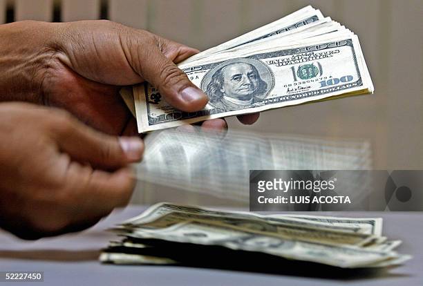 Un empleado de una casa de cambio cuenta dolares estadounidenses en Bogota el 22 de febrero de 2005. El precio del dolar en Colombia cayo al nivel de...