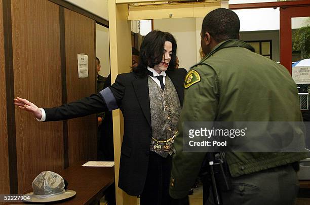 Singer Michael Jackson is screened by a sheriff's deputy as he arrives at the Santa Barbara County Courthouse for continuation in the jury selection...