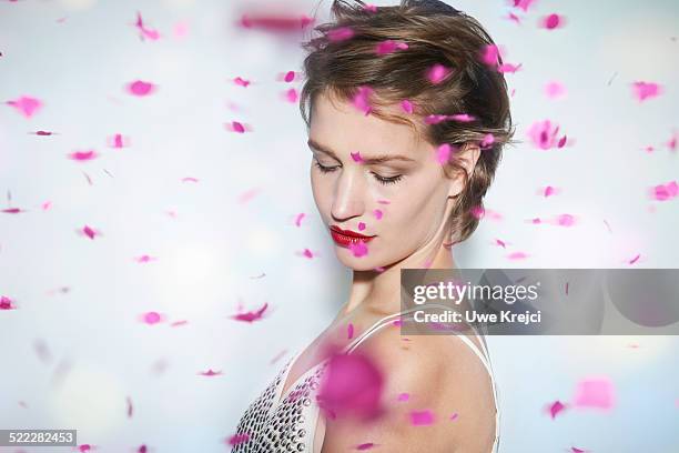 young woman with rain of pink confetti - makeup in rain photos et images de collection