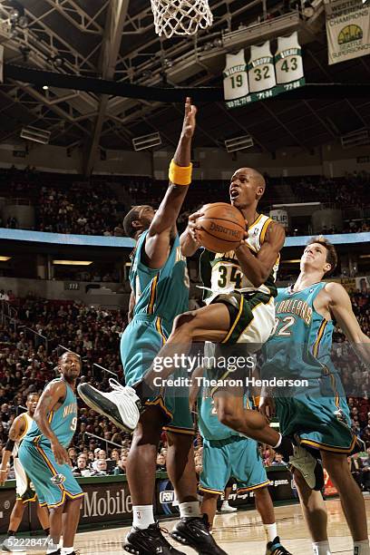 Ray Allen of the Seattle Sonics shoots against Rodney Rogers of the New Orleans Hornets during the game on February 8, 2005 at Key Arena in Seattle,...