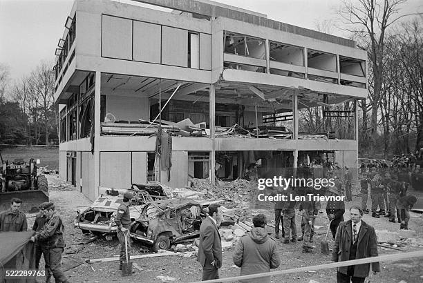 Soldiers and firefighters at the scene of a car-bombing by the Official Irish Republican Army at the headquarters of the British Army's 16th...