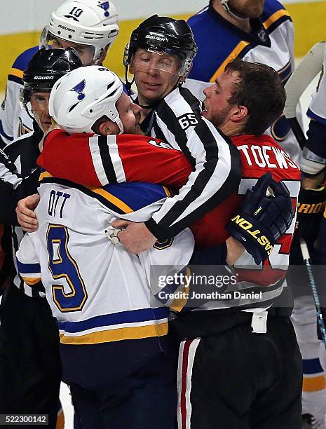 Linesman Pierre Racicot gets between Steve Ott of the St. Louis Blues and Jonathan Toews of the Chicago Blackhawks in Game Three of the Western...