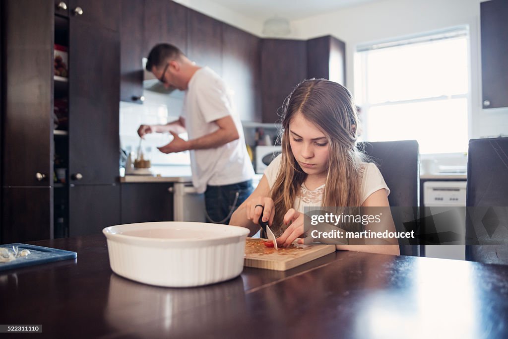 Padre e hija, preparación de alimentos en su cocina.
