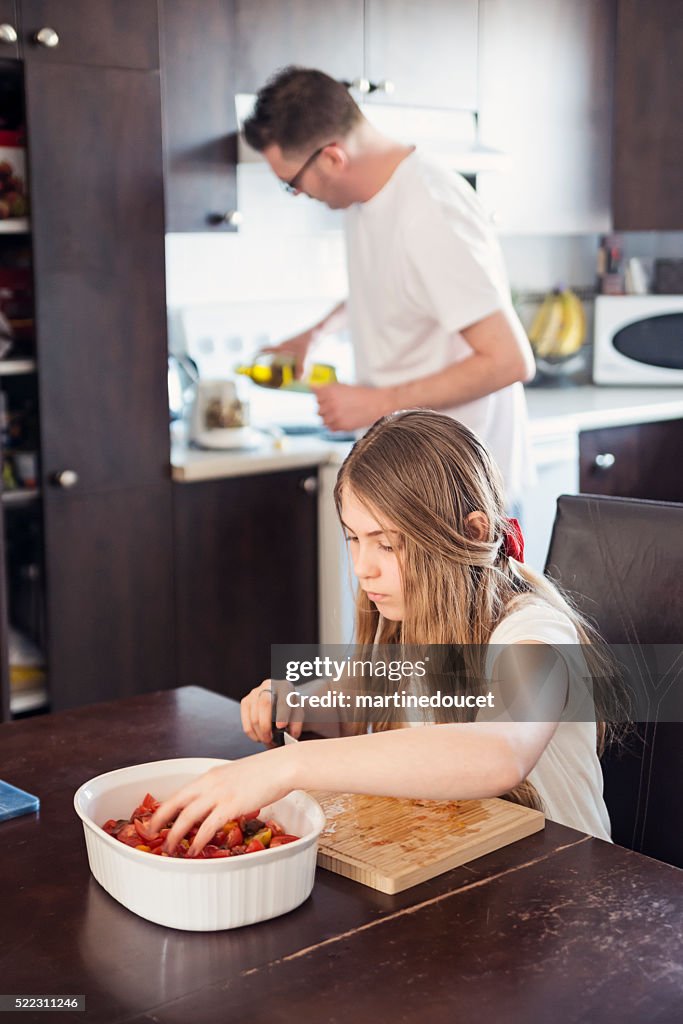 Padre e hija, preparación de alimentos en su cocina.