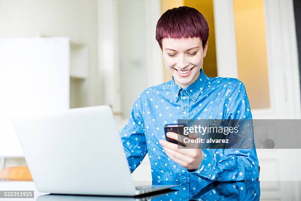 young businesswoman reading text massage at her desk - mobile massage table stock pictures, royalty-free photos & images